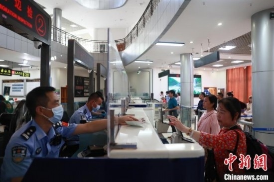 圖為旅客在磨憨口岸辦理通關(guān)手續(xù)。雷雨 攝