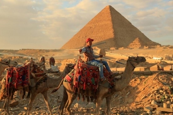1月24日，商販騎駱駝離開埃及吉薩金字塔景區(qū)。新華社記者 隋先凱 攝