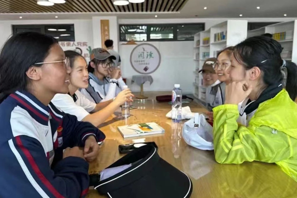 2023年7月10日，在果洛西寧民族中學，上海市大同中學學生（右）與果洛西寧民族中學學生交流。新華社發(fā)（果洛州教育局供圖）