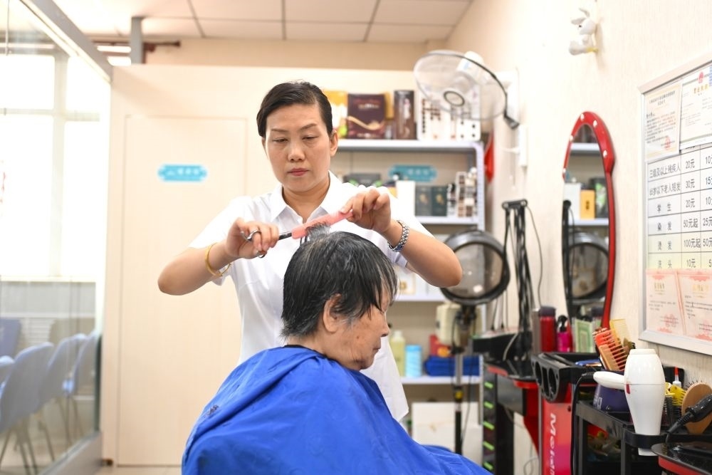 6月20日，長城花園社區(qū)的志愿者為居民理發(fā)。