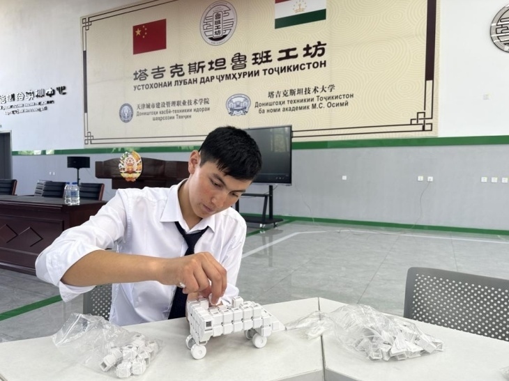 在塔吉克斯坦魯班工坊內(nèi)，學員正在操作能力源創(chuàng)新套件。本報記者 屈佩 攝