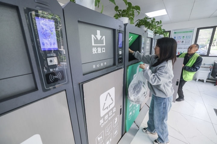 2024年4月10日，在浙江省湖州市吳興區(qū)飛英街道新華府小區(qū)內(nèi)，居民在垃圾分類智能系統(tǒng)的指導(dǎo)下進行垃圾分類投放，居民的投放情況將實時匯總到智慧服務(wù)平臺，會有相應(yīng)的積分獎勵。新華社記者 徐昱 攝