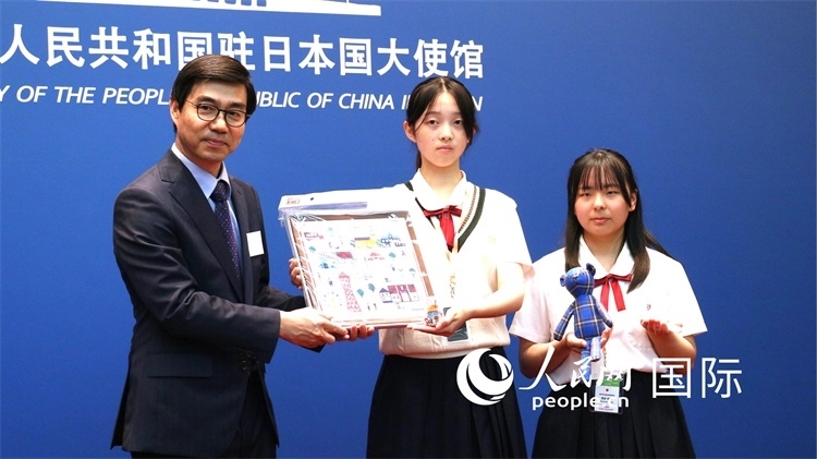 日本小大使向中國駐日本大使館臨時代辦施泳贈送當?shù)靥厣Y品。人民網(wǎng) 許可攝