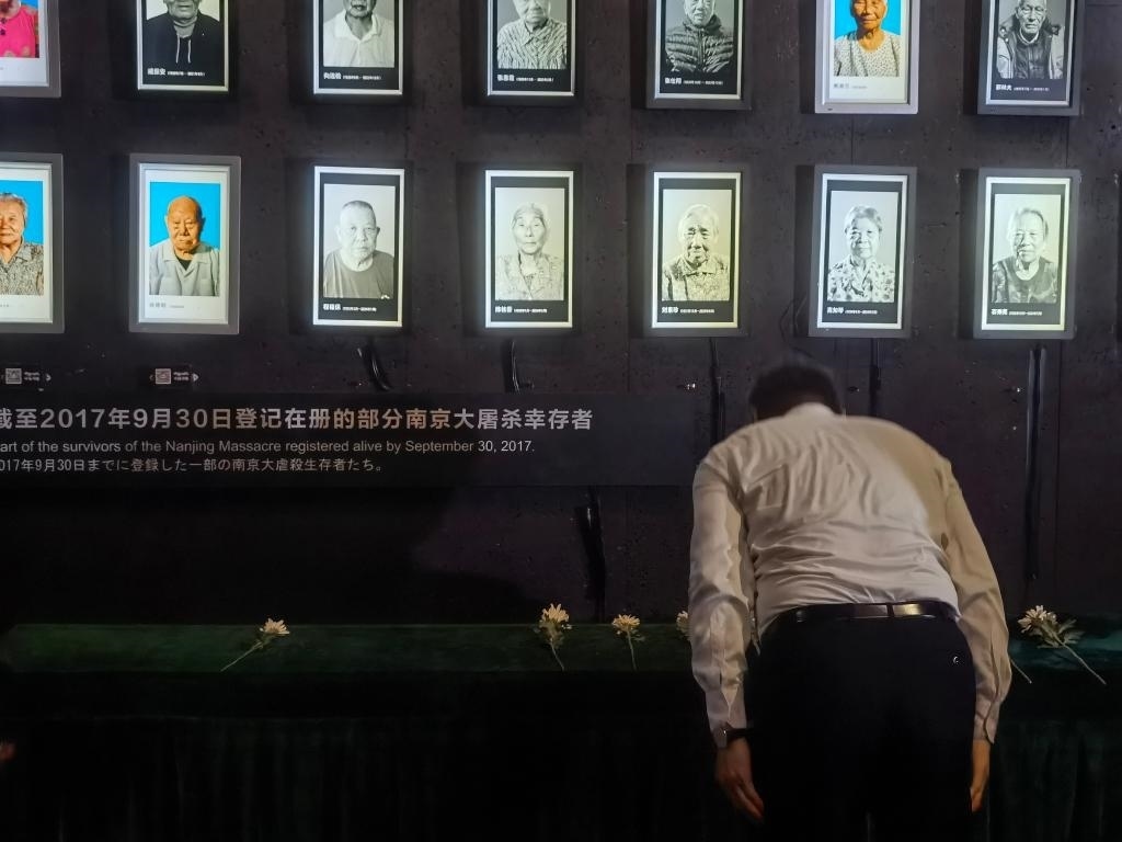 7月18日，人們向離世的南京大屠殺幸存者獻(xiàn)花、鞠躬。新華社記者邱冰清 攝