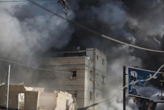 7月21日，在加沙地帶中部的努賽賴特難民營(yíng)，遭以軍空襲的建筑冒出滾滾濃煙。新華社發(fā)（馬爾萬(wàn)·達(dá)烏德攝）