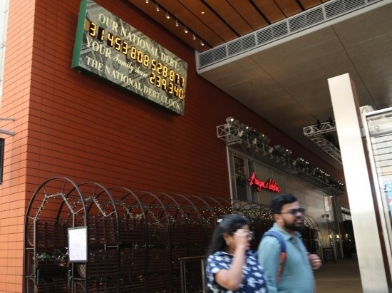 2023年5月29日，人們經(jīng)過美國紐約曼哈頓的“國債鐘”?！皣鴤姟笔且粋€大型計數(shù)器，它實時更新美國的公共債務(wù)總額，并顯示出每個美國家庭所要負(fù)擔(dān)的數(shù)額。 新華社記者劉亞南攝