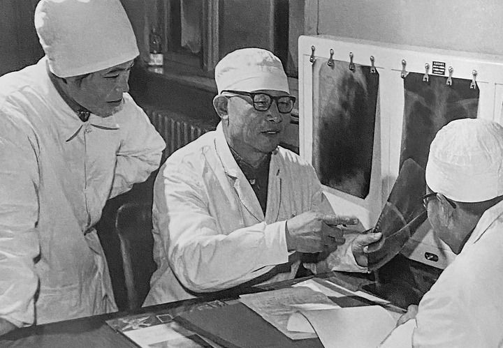 1980年1月16日，中日友好醫(yī)院首任院長辛育齡（中）在內(nèi)蒙古結(jié)核病院與胸外科醫(yī)師討論病例（翻拍照片）。 新華社發(fā)