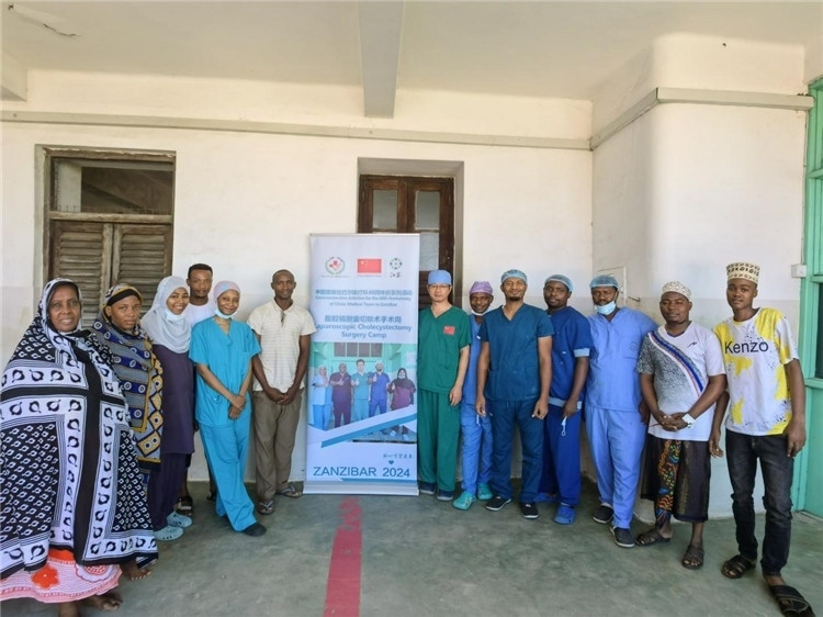 隊(duì)長蔣國慶（右七）和手術(shù)醫(yī)生、部分患者合影。中國援桑醫(yī)療隊(duì)供圖