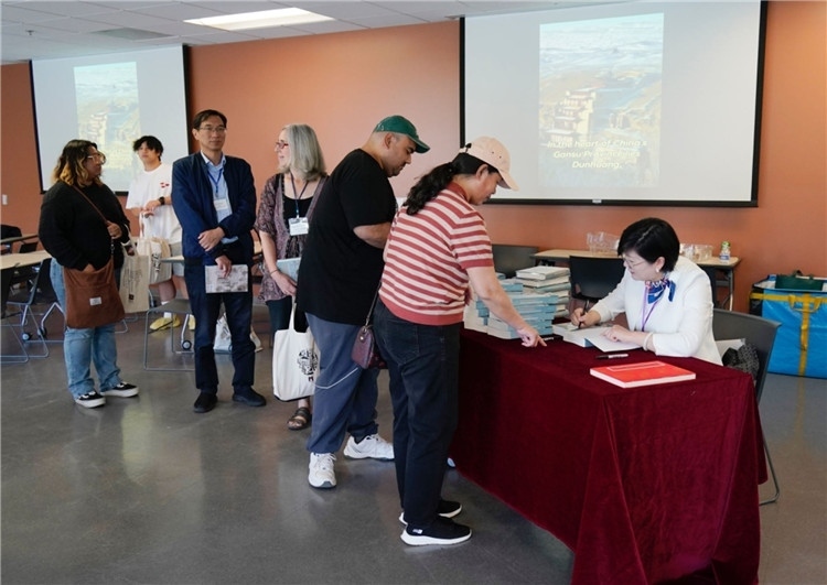 作者顧春芳在活動現(xiàn)場簽名贈書。羅先勇攝