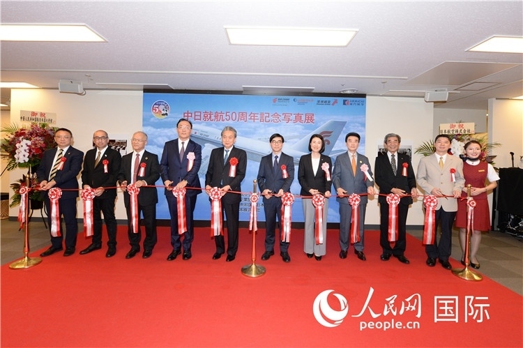 與會(huì)嘉賓共同為中日通航50周年紀(jì)念圖片展開(kāi)幕剪彩。馮學(xué)敏攝