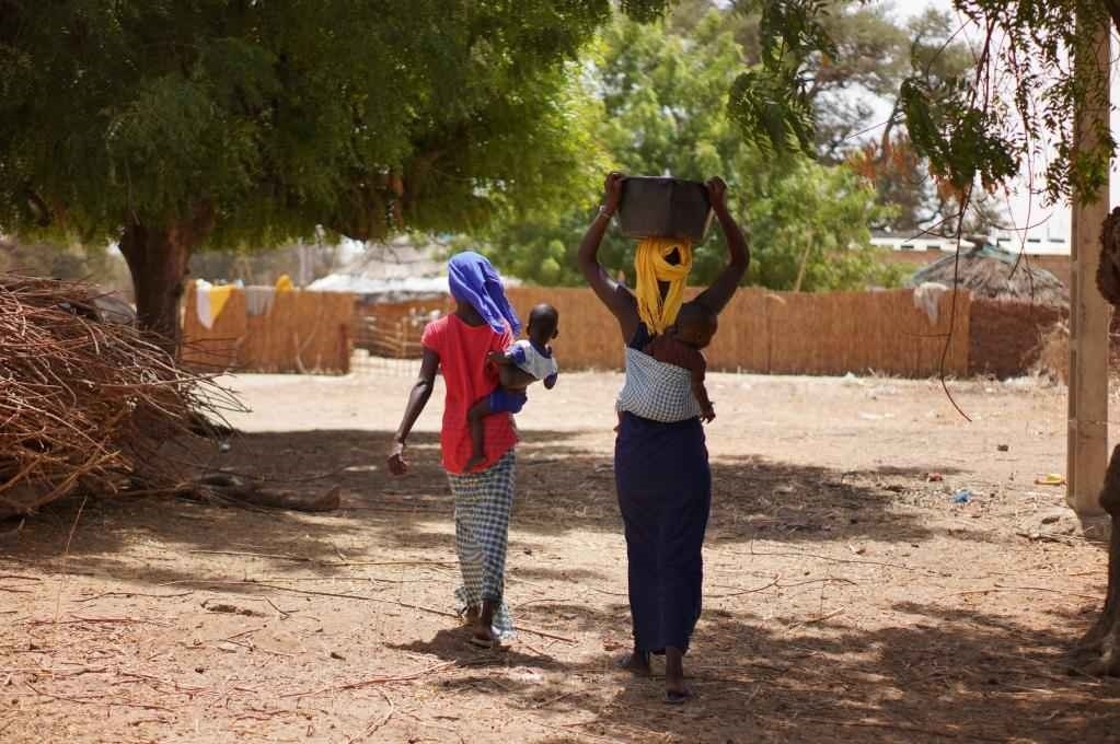 2023年3月20日，在塞內(nèi)加爾久爾貝勒區(qū)的泰內(nèi)富勒村，村民將取到的水運(yùn)回家。新華社記者 王子正 攝