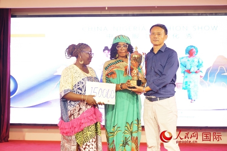 中國(guó)駐尼日利亞使館文化參贊兼中國(guó)文化中心主任李旭大（右）為最佳表現(xiàn)獎(jiǎng)?lì)C獎(jiǎng)（中）。人民網(wǎng)記者 姜宣攝