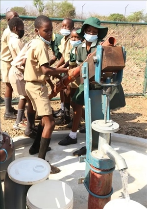 △2021年11月，在津巴布韋南馬塔貝萊蘭省省會(huì)關(guān)達(dá)的塞農(nóng)多小學(xué)，學(xué)生從中國(guó)援建水井里打水。