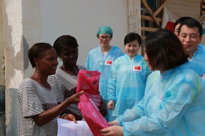 2015年4月4日，在位于塞拉利昂首都弗里敦市郊的中塞友好醫(yī)院埃博拉診療中心，中國第四批援塞醫(yī)療隊(duì)副隊(duì)長邵蔚（右前）向被治愈的埃博拉出血熱患者贈送禮物。新華社發(fā)（祖榮強(qiáng) 攝）