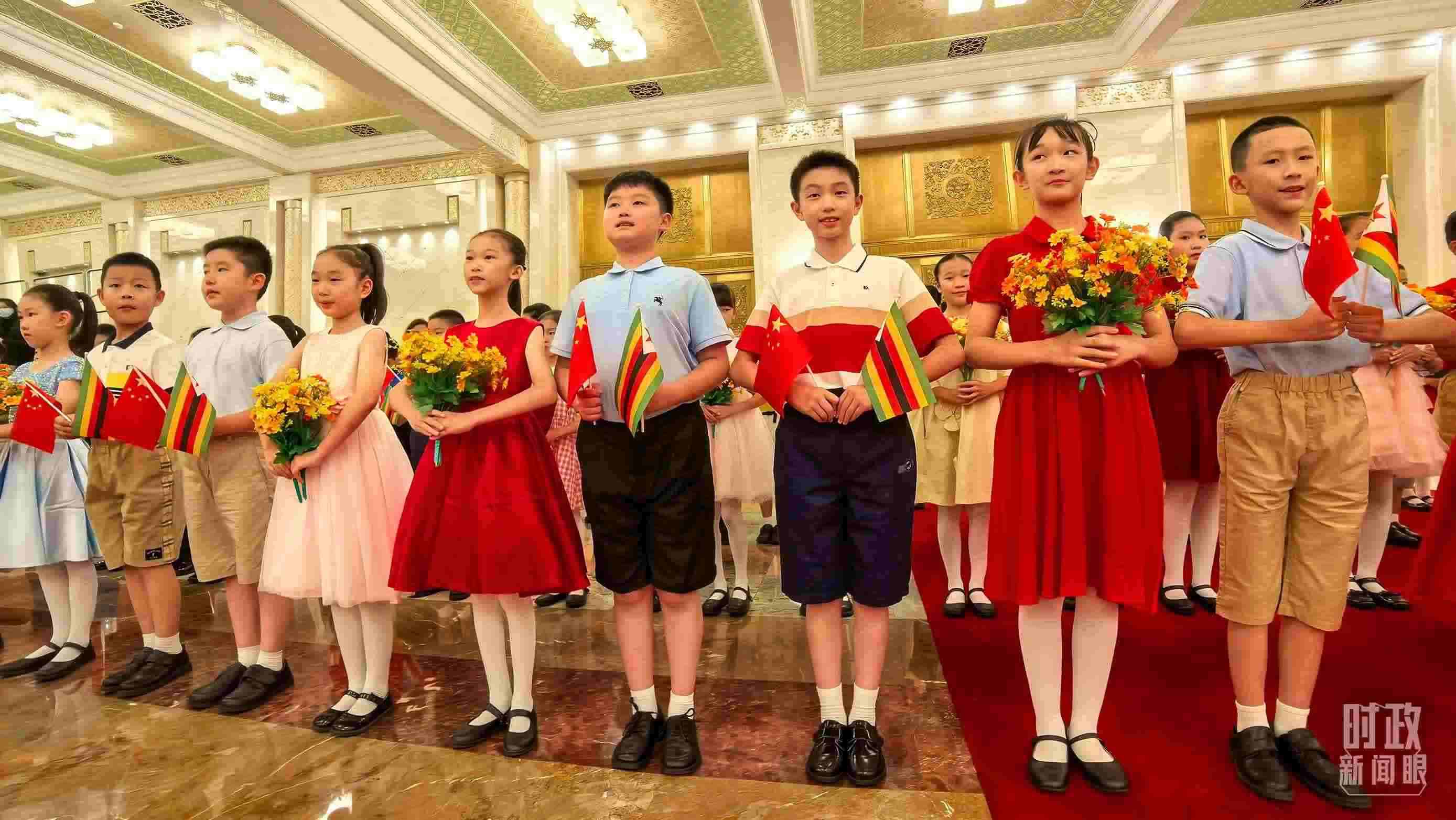 △現(xiàn)場歡迎津巴布韋總統(tǒng)訪華的青少年。（總臺央視記者鐘銳拍攝）