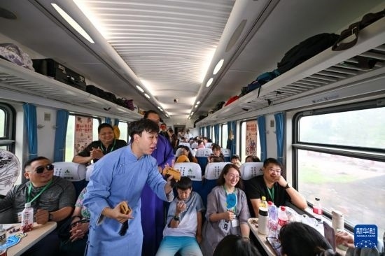 9月7日，相聲演員在S910列車上為旅客表演快板。