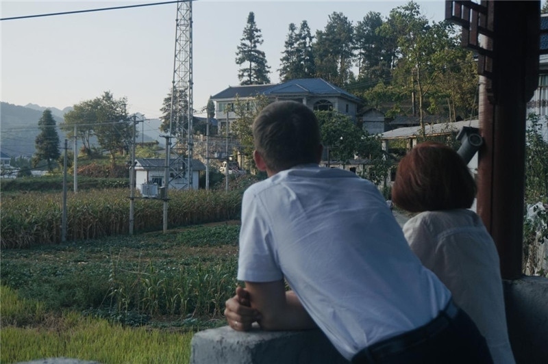 望得見山，看得見水，記得住鄉(xiāng)愁。每個人心中都有一個屬于自己的“花茂村”，在這方心田，走遍千山萬水，鄉(xiāng)音未改鬢毛衰。吉爾吉斯斯坦《比什凱克晚報》第一副總編輯妮娜·尼奇博洛娃與《中國與俄羅斯》雜志社社長奧列格·別列日內(nèi)赫攝在花茂村民居屋檐下并肩佇立，眺望山水，尋覓鄉(xiāng)愁。（李光裕攝）