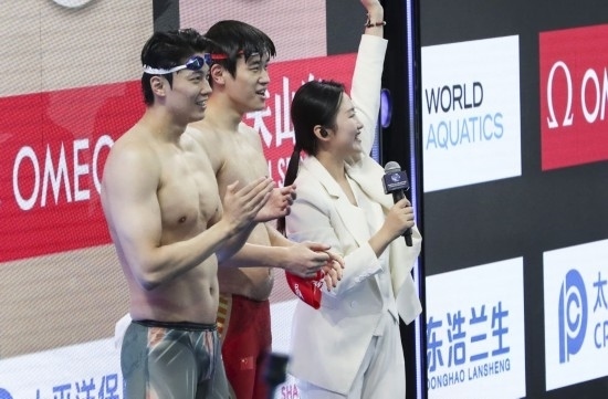  10月18日，汪順（左）和潘展樂在男子100米混合泳決賽后。新華社記者 方喆 攝