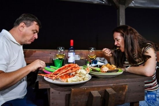 9月2日，食客們?cè)诙砹_斯符拉迪沃斯托克的一家餐館品嘗帝王蟹。新華社記者 曹陽(yáng) 攝