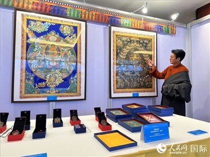 熱貢藝術(shù)國家級代表性傳承人夏吾角向嘉賓介紹作品。人民網(wǎng)記者 簡承淵攝