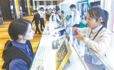 在北京麗澤商務(wù)區(qū)，工作人員（右一）介紹數(shù)字人民幣SIM卡硬錢包。新京報(bào)記者 陶冉攝