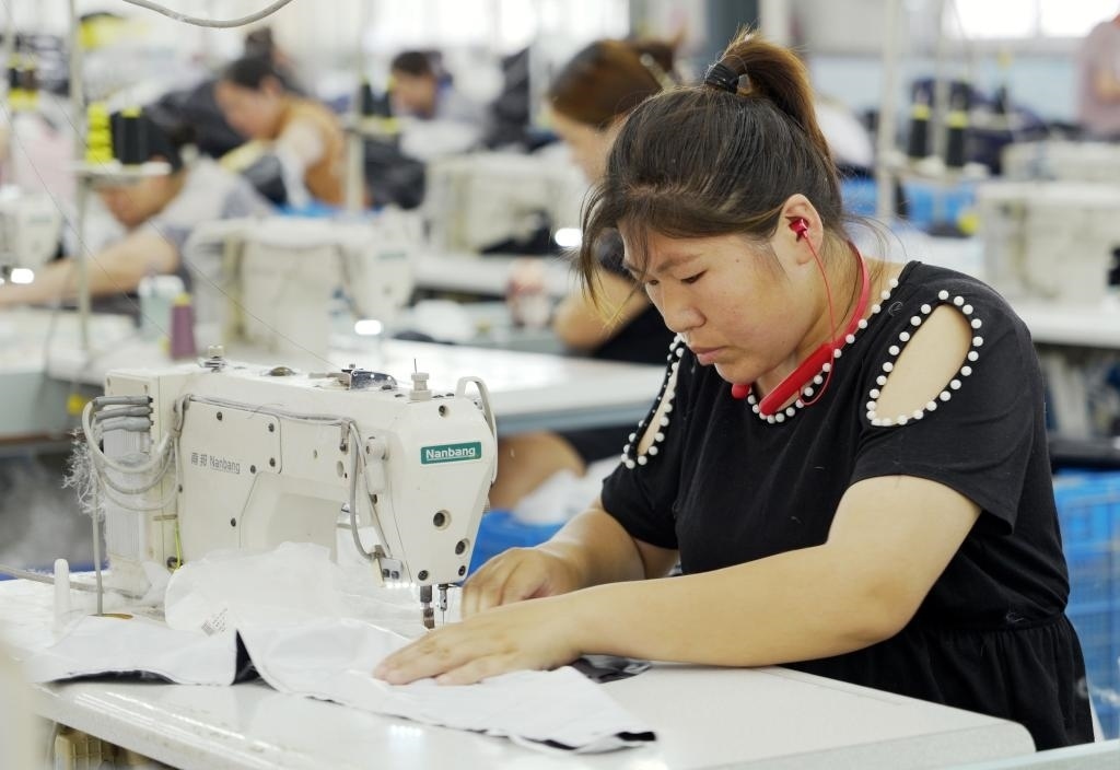 5月20日，村民在李寨村服裝加工廠內(nèi)忙碌。河南省周口市沈丘縣馮營鎮(zhèn)李寨村地處豫東平原。近年來，乘著脫貧攻堅(jiān)與鄉(xiāng)村振興政策的東風(fēng)，李寨村積極探索產(chǎn)業(yè)發(fā)展模式，通過“龍頭企業(yè)+村集體經(jīng)濟(jì)+農(nóng)戶”的方式，逐漸發(fā)展形成肉牛養(yǎng)殖、設(shè)施農(nóng)業(yè)、服裝加工、康養(yǎng)民宿等產(chǎn)業(yè)，以產(chǎn)業(yè)振興助力鄉(xiāng)村振興。新華社記者 李嘉南 攝