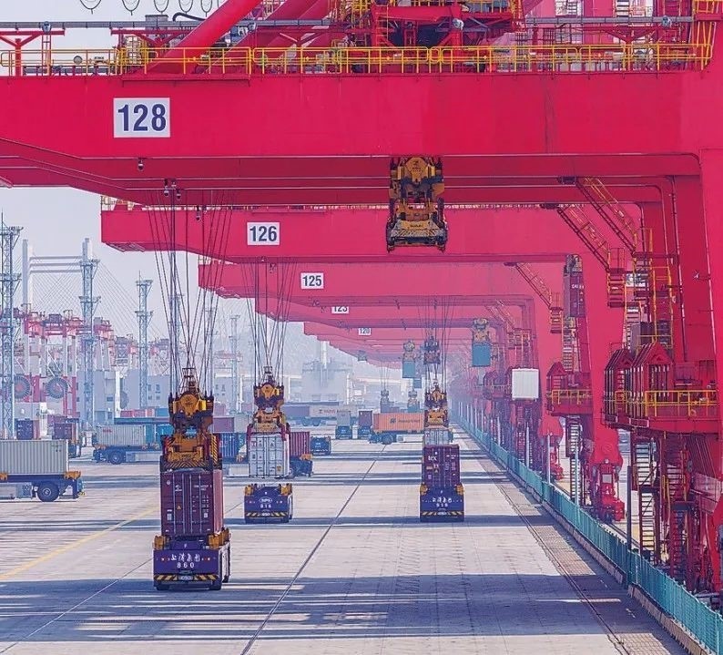 共建“一帶一路”國家在工作制度對接、技術(shù)標(biāo)準(zhǔn)協(xié)調(diào)、檢驗結(jié)果互認(rèn)等方面強(qiáng)化合作、統(tǒng)一標(biāo)準(zhǔn)，貿(mào)易自由化便利化水平不斷提升。上海洋山港海關(guān)對接共建國家進(jìn)出口貨物相關(guān)標(biāo)準(zhǔn)，推動通關(guān)一體化方式申報，提升通關(guān)效率。圖為無人駕駛的全自動導(dǎo)引車在洋山港穿梭往來，搬運集裝箱。王初 攝