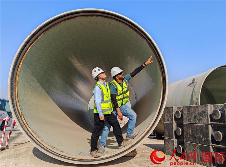 工作人員在察看輸水管情況。人民網(wǎng)記者 管克江攝