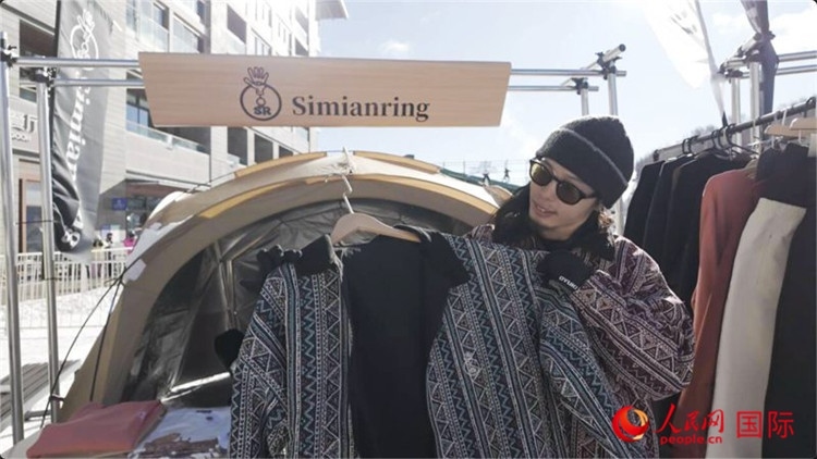 藤田周正在展示自己設(shè)計(jì)的滑雪服。人民網(wǎng)記者 袁蒙攝