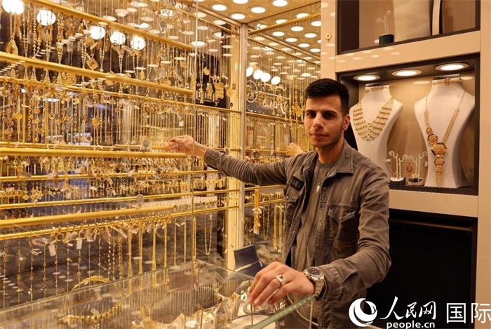 一名銷售員展示黃金飾品。人民網(wǎng) 伊納斯·易卜拉欣攝
