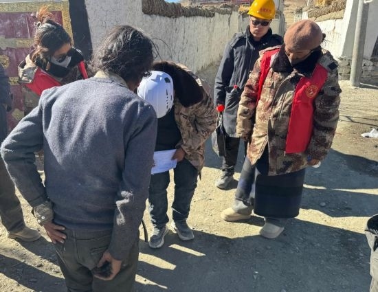 1月13日，次旺（右一）陪同工作組走訪村莊，評估房屋受損程度。新華社發(fā)