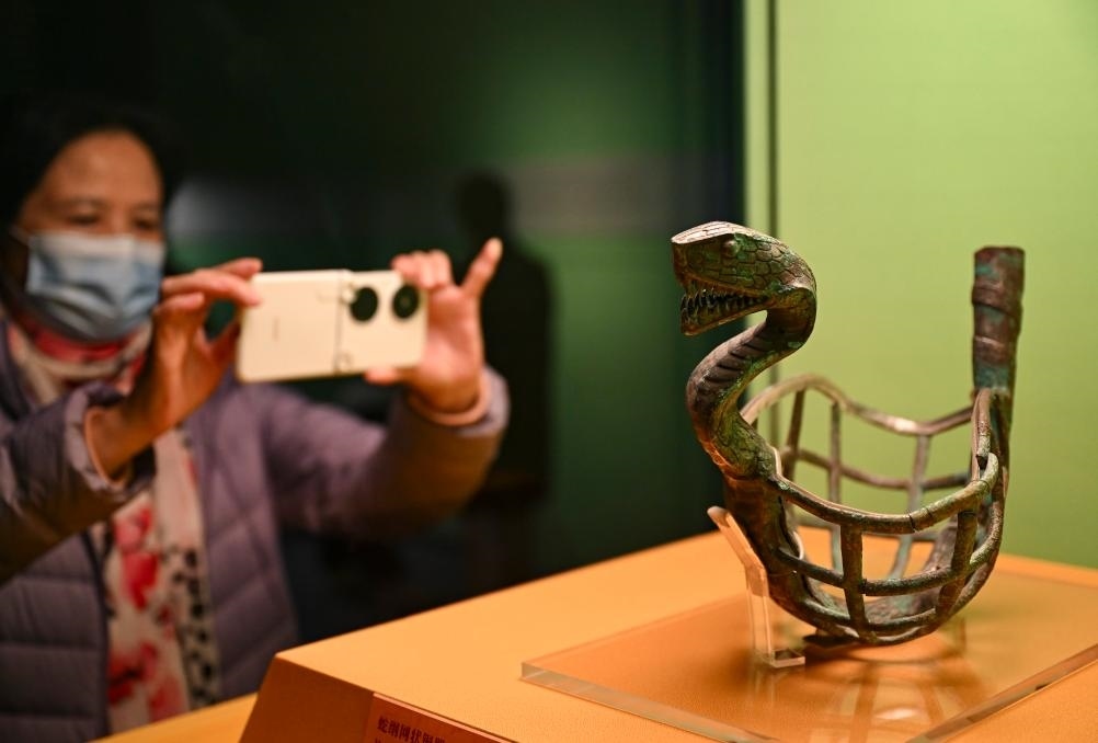 1月14日，觀眾在上海博物館蛇年迎春展拍攝展品蛇綱網(wǎng)狀銅器。新華社發(fā)（陳浩明攝）