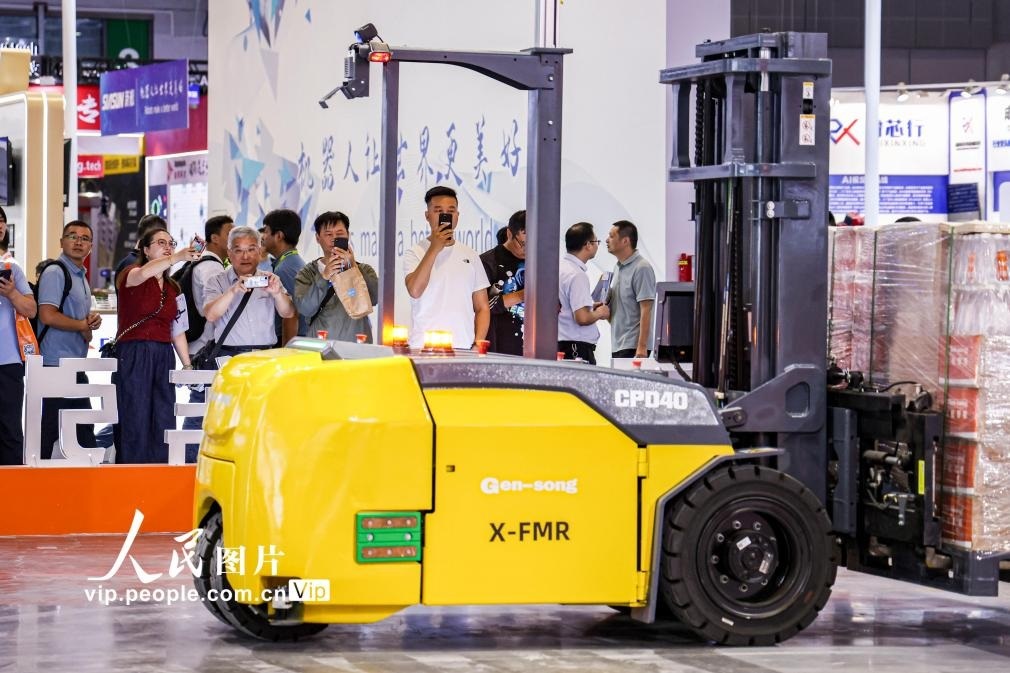 第24屆中國(guó)工博會(huì)現(xiàn)場(chǎng)，觀(guān)眾觀(guān)看叉取機(jī)器人作業(yè)演示。王初攝（人民圖片網(wǎng)）