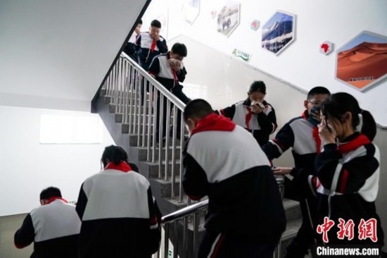  圖為學(xué)生們進(jìn)行應(yīng)急疏散演練。中新社記者 趙宇航 攝