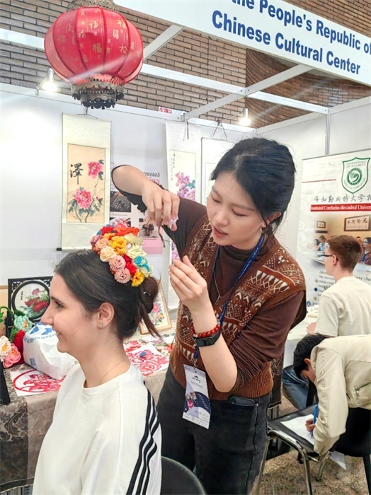 展覽正值羅馬尼亞迎春花節(jié)，國際中文教師志愿者潘婧穎向游客們介紹了國家非物質(zhì)文化遺產(chǎn)——福建泉州的簪花文化。布加勒斯特大學(xué)孔子學(xué)院供圖。