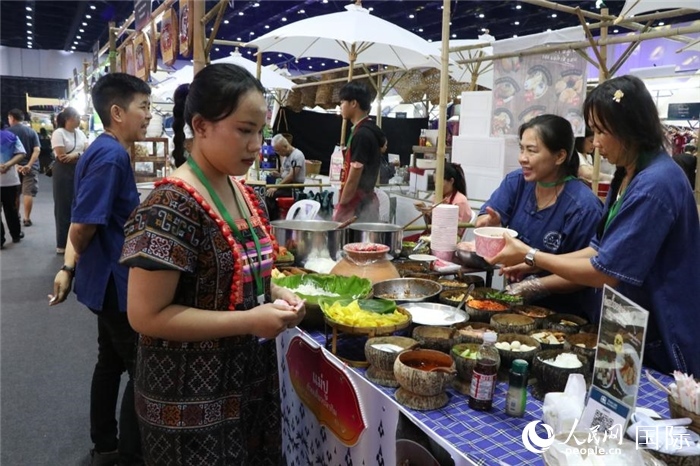 游客在攤位前購買特色美食。朱瀟逸攝