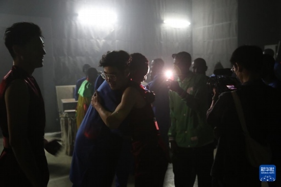 4月10日，在塞內加爾首都達喀爾的國家大劇院，中央音樂學院進擊打擊樂團成員與塞內加爾杜杜·恩迪亞耶·羅斯打擊樂團成員在演出后臺擁抱。新華社記者 司源 攝