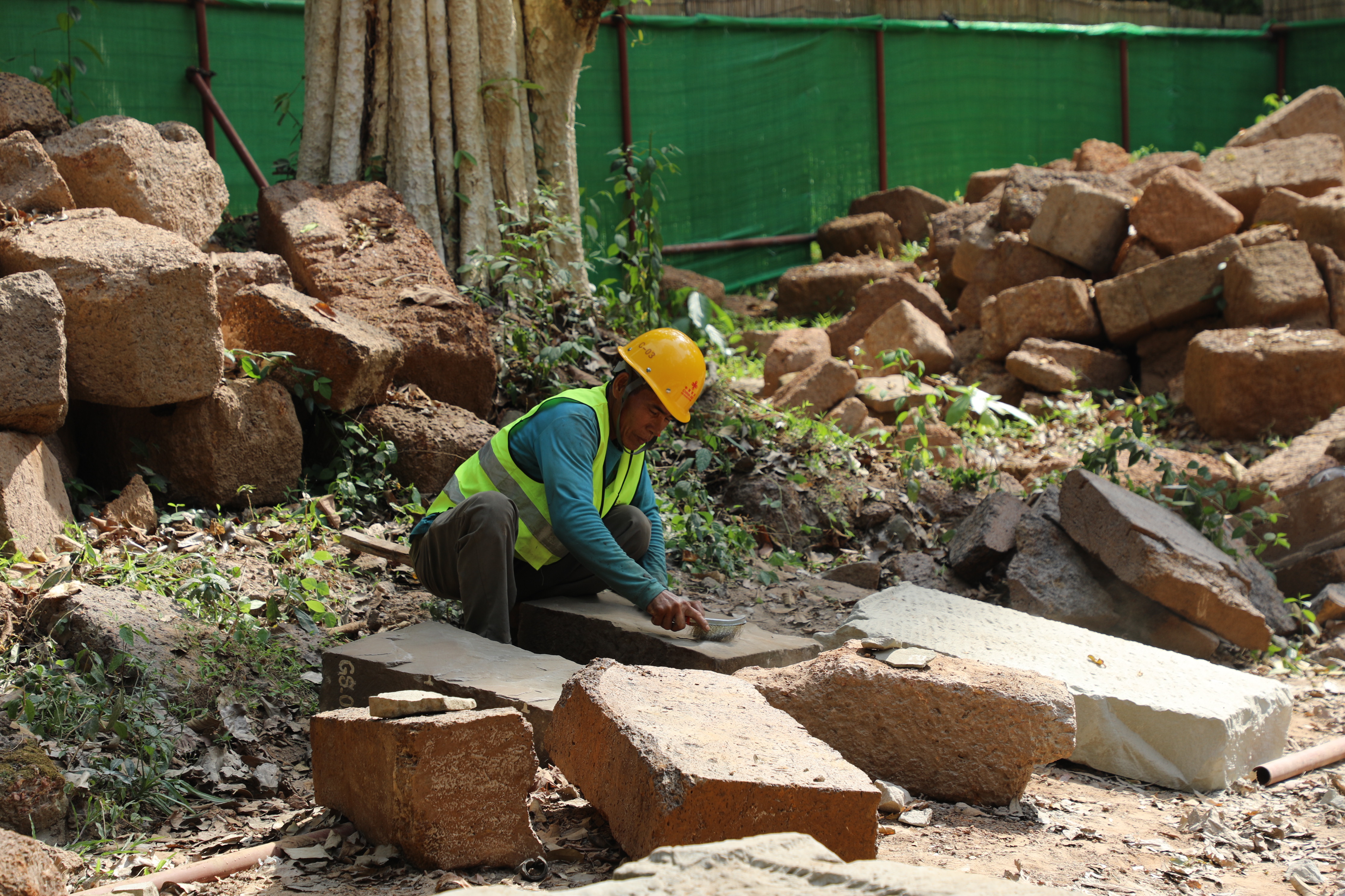 一名柬埔寨工人正在王宮遺址修復(fù)現(xiàn)場(chǎng)工作。（人民日?qǐng)?bào)記者曹師韻 攝）