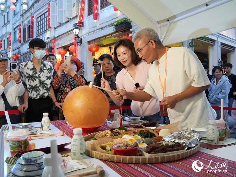 嘉賓品嘗海南傳統(tǒng)美食“煎堆”。人民網(wǎng)記者 張力洋攝