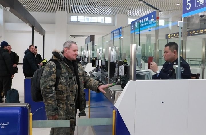 2024年12月10日，在黑河公路口岸旅檢大廳，黑河出入境邊防檢查站民警為首班次客車入境旅客辦理邊檢通關(guān)手續(xù)。當(dāng)日，中國黑河公路口岸—俄羅斯卡尼庫爾干公路口岸旅客運輸正式開通。新華社發(fā)（劉松攝）