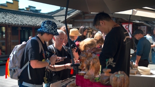 “五一”期間，游客正在烏鎮(zhèn)“水鄉(xiāng)碼頭”挑選購買文創(chuàng)產(chǎn)品。受訪者供圖