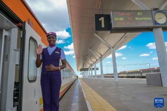 5月31日，在蒙內(nèi)鐵路內(nèi)羅畢站，一名乘務(wù)員在即將開往蒙巴薩的E2次列車旁等候乘客。新華社記者 楊光 攝