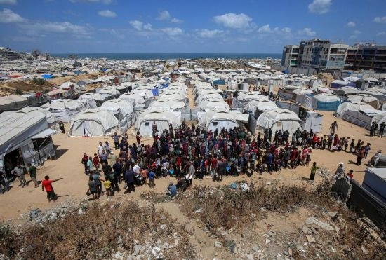 5月28日，人們在加沙城西部的沙提難民營等待領(lǐng)取救助食物。新華社發(fā)（里澤克·阿卜杜勒賈瓦德攝）