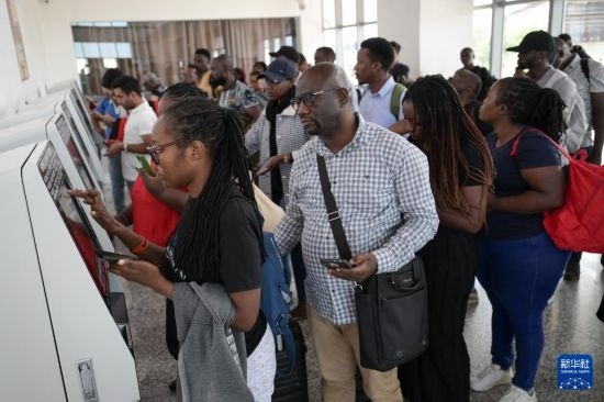 5月31日，在蒙內(nèi)鐵路內(nèi)羅畢站，乘客在自助取票機(jī)前排隊(duì)取票。新華社記者 楊光 攝