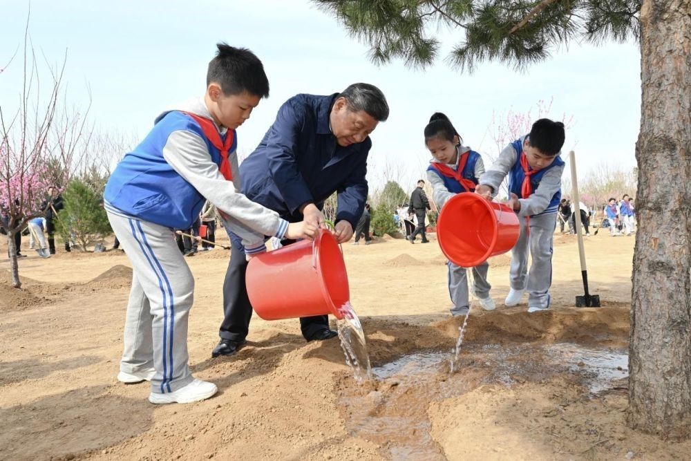 2025年4月3日，習(xí)近平總書記等來(lái)到北京市豐臺(tái)區(qū)永定河畔參加首都義務(wù)植樹活動(dòng)。這是習(xí)近平總書記同少先隊(duì)員一起給剛栽下的樹苗澆水。新華社記者 謝環(huán)馳 攝